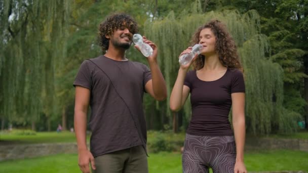 Deportivo Feliz Diversa Pareja Multirracial Beber Agua Botella Parque Árabe — Vídeo de stock