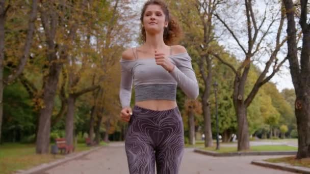 スポーツアスリートコーカサス女性ランナーのジョギングガールスポーツ女性が朝の屋外で実行 健康的なライフスタイル ボディケア 都市活動フィットネスでジョギングを失った — ストック動画