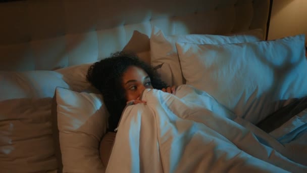 Afroamerykanka Łóżku Przykrywając Kołdrę Udawać Przestraszony Koszmar Ciemnej Sypialni Etniczny — Wideo stockowe