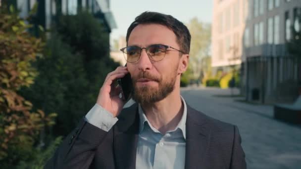 Счастливый Улыбающийся Кавказский Мужчина Разговаривает Мобильный Телефон Гуляет Открытом Воздухе — стоковое видео