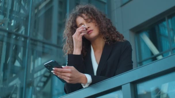 コーカサス州の若い女の子ビジネス女性の従業員の労働者は疲れた疲れました 問題外のオフィスバルコニーの悲しい実業家 携帯電話の悪いニュース スマートフォン メッセージ 屋外で — ストック動画