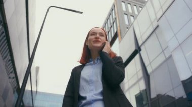 Beyaz, mutlu, güler yüzlü, neşeli, kadın, kadın, yönetici, iş adamı, iş adamı gülümseme, telefon dostça, hoş sohbetler, şehirdeki akıllı telefonlardan gelen aramalar.
