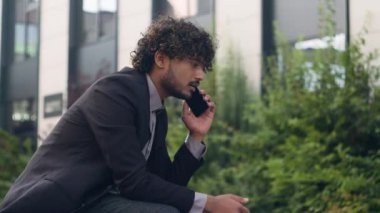 Endişeli Hintli işadamı Arap iş adamı lider girişimci yönetici cep telefonundan konuşuyor kötü haberler dinliyor şehir sorununda kurumsal akıllı telefon sohbeti