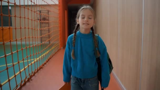 小女孩在体育馆上小学体育课时面带微笑快乐的小女孩在室内体育活动与书包一起训练的小学生小孩徒步走女学生运动 — 图库视频影像