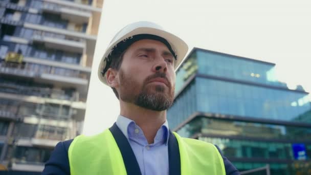 都市建築建築ビルダー事業建設エンジニアを中心に ヘルメットと反射ベスト建築家ペンシブ思考を身に着けている白人中年の男性請負業者 — ストック動画