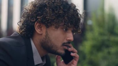 Endişeli Hintli işadamını kapat stresli Arap iş adamı Girişimci Hispanik yönetici konuşuyor cep telefonu cevap kötü haber işitme sorunu baş ağrısı