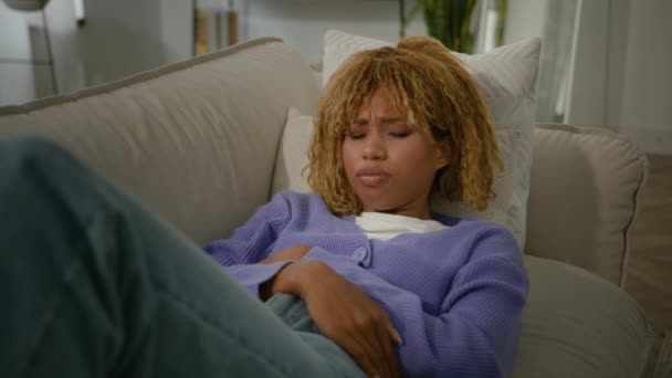 非洲裔美国人忧心忡忡女人躺在沙发上感觉肚子痛肚子便秘女性疾病月经期健康问题胃病 — 图库视频影像