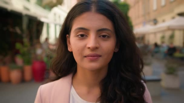 落ち着いた若いインドのアラビアの民族女性の女性の学生のビジネスマンは ゆっくりと目を開く外の街のストリートカフェに立っています フレンドリーな広い歯の健康的な笑顔の歯科ケア — ストック動画