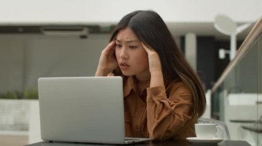 Asyalı üzgün kadın yorgun, bitap düşmüş Koreli Japon iş kadını laptopçu işinde endişeli kız, bilgisayardaki kötü haber üzerine stres bozukluğu yaşıyor.