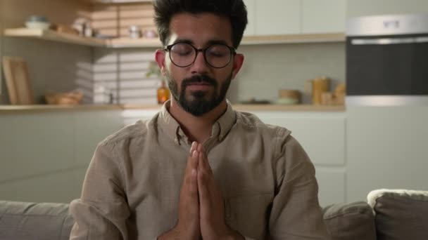 和平的阿拉伯印第安人男人闭眼睡在家里的沙发上厨房冥想练习瑜伽纳马放松无拘无束感觉平静和谐平衡舒适禅定精神意识 — 图库视频影像