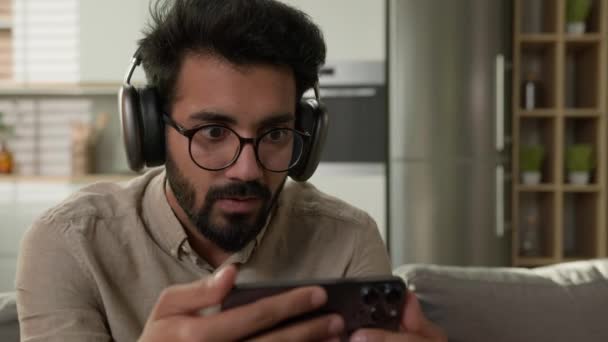 Sorprendido Hombre Árabe Indio Feliz Auriculares Ver Flujo Vídeo Teléfono — Vídeos de Stock