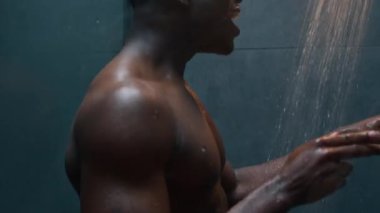 Komik, neşeli adam duş al, duş al, rahatla, Afrikalı, Amerikalı, etnik, mutlu adam ev banyosunda şarkı söyle, müzik dinle, dans et, enerji içir, sıcak su dök, banyo yap.