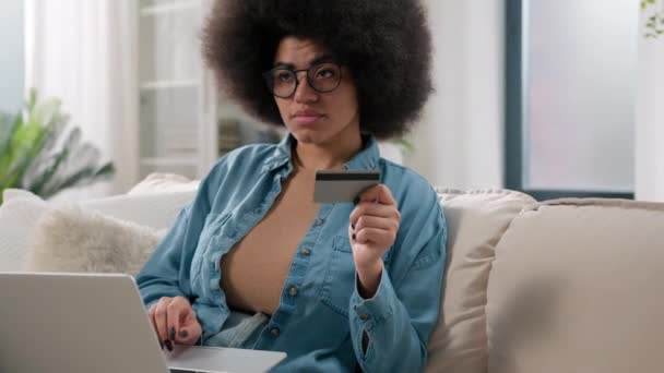 アフリカ系アメリカ人の思慮深いクライアント女性バイヤーの女性の女性の女性の少女は ペンシブは ラップトップコンピュータと銀行のクレジットカードでポンダーショッピングを決定します 支払いインターネットは 自宅で商品を購入する — ストック動画