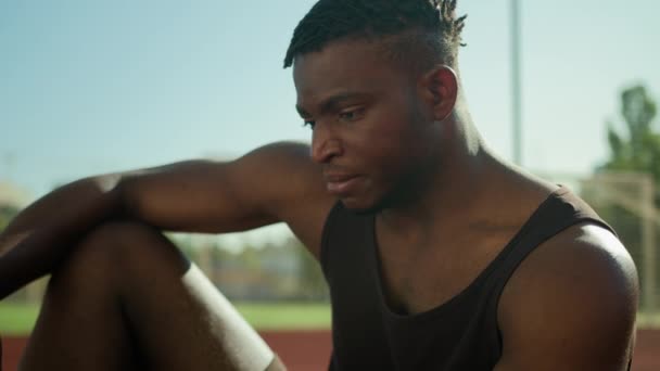 非洲裔美国人严重30多岁的男人厌倦了运动员在运动场上浏览手机上网成瘾不快乐的男性体育教练在城市里用智能手机锻炼休息 — 图库视频影像