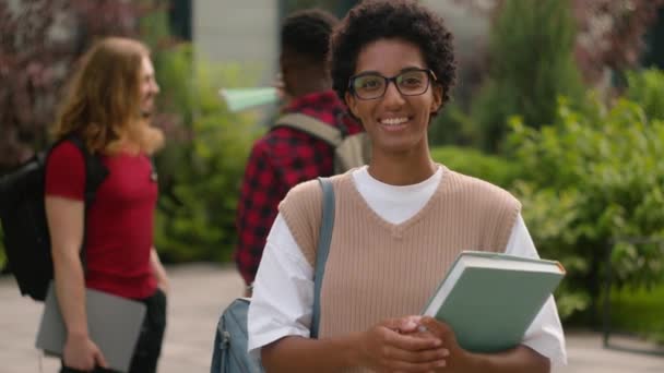 アフリカの大学キャンパスの近くで話す学生 アフリカ系アメリカ人の幸せな満足した学生少女の女性は 授業後のジェスチャーのような親指を示す 良い高校の知識を持つ — ストック動画
