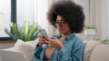 Afro-Amerikalı iş kadını etnik kız serbest çalışan kız. Evdeki kanepede dizüstü bilgisayarlı öğrenci kullanıcısı. İşi gevşet.