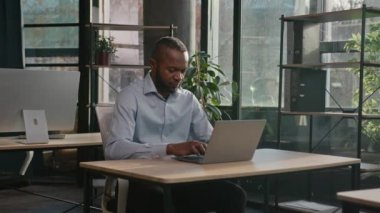 Profesyonel orta yaşlı, 40 'lı yaşlarda, etnik Afro-Amerikan iş adamı kıdemli işadamı. Ofis çalışanı, kapalı bir yerde oturup bilgisayar ağındaki net verileri araştırıyor ve gülümseyen olumlu gülümsemeye bakıyor.
