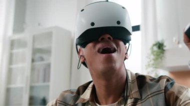 Heyecanlı Afrikalı erkek oyuncu oyun bağımlısı erkek VR gözlüklü kapalı meta-dünya meta-uzay eğlence deneyimi kullanarak sanal gerçeklikte telefon çalıyor.