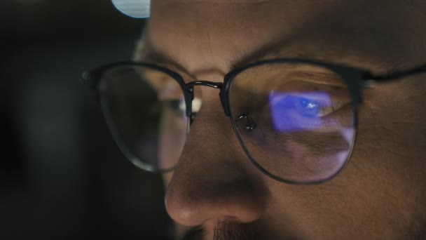 戴眼镜的男性眼睛紧闭眼睛眼力问题药物之夜黑暗男人商人开发人员计算机程序员商人看着屏幕上蓝色笔记本电脑显示器镜像中的倒影 — 图库视频影像