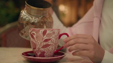 Bitkisel çay bardağını dolduran kadın. Sıcak aroma. Lezzetli içecek, restoran tatmini.