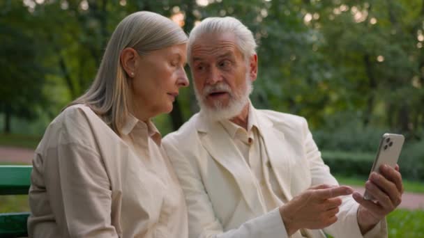 Пожилой Белый Седой Муж Держит Показывая Мобильный Телефон Объясняя Обсудить — стоковое видео
