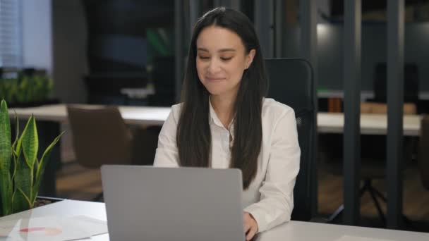 インスパイアされたモチベーションのコーカサス笑顔ビジネス女性は ノートパソコンの職場笑顔でオフィステーブルで働いています 満足したビジネスマンは コンピュータタタスクを考えて 仕事の良い結果を達成するためにオンラインで働きます — ストック動画