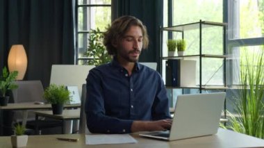 Arap ortadoğulu etnik adam iş adamı yazılım programcısı ofis çalışanı yönetici yönetici yönetici iş adamı dizüstü bilgisayar şirketi ile çalışan kameralı gülümsemeye bakan iş adamı