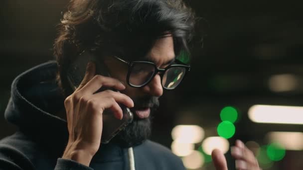 紧闭严重不愉快的印度紧张的戴眼镜男人谈论手机冲突在黑暗停车场听坏消息 阿拉伯国家的人在智能手机上谈论悲惨的商业问题 — 图库视频影像