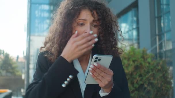 街のビジネスネットワーキングアウトドアで携帯電話を持つ白人ビジネスマンは驚きました 良いニュース 女性は驚きの衝撃を叫ぶモバイル勝利を勝ち取る喜び 幸せなキス スマートフォンユーフォリア — ストック動画