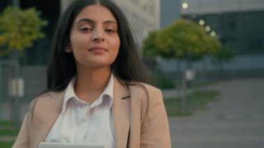 Hintli kız öğrenci resmi Arap iş kadını kadın işveren kadın girişimci yönetici, stajyer kadın yönetici şehir merkezindeki fotoğrafa gülümseyen dijital tablet taşıyor.