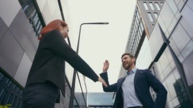 Mutlu iş ortakları başarılı iş adamları Kafkasyalı iş arkadaşları iş arkadaşları iş kadını ve iş kadını ofis binası yakınında başarı ortaklığını kutluyor.