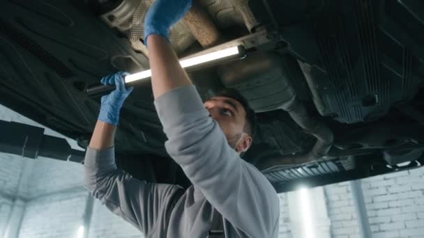Автомобільний Інженер Механік Кавказький Чоловік Тримає Освітлювальне Обладнання Під Автомобілем — стокове відео