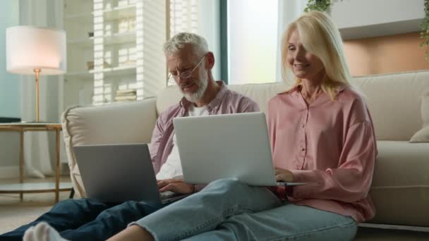 コーカサス微笑む家族カップル男性の女性の祖父母は コンピュータアプリケーションを使用して自宅のリビングルームでリモートで働いています 電子メールを閉じるラップトップをチェック よくやった成功の仕事を祝う — ストック動画