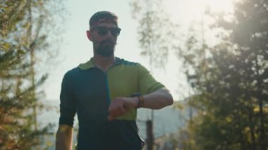 Kendinden emin, mutlu, beyaz, erkek, koşucu dijital akıllı saat fitness bileziği teknolojisi koşusu maraton koşusu sağlıklı sağlık eğitimi doğa sporu.