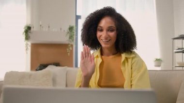 Mutlu Afro-Amerikalı kadın gülümseyen kıvırcık saçlı kadın ev sahibi bilgisayarlı görüntülü sohbet bilgisayarlı laptop web kameralı konferans sanal konferans görüşmesi evdeki karantinada