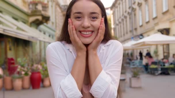 年轻快乐的白种人女人快乐的笑着牙笑着快乐的满足的女人看着相机高兴的样子快乐的女孩城市街道外的手势庆祝好心情城市的成功 — 图库视频影像