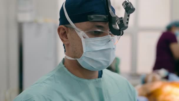 近门诊部医生 专业外科医生 身穿医用制服 双目双目 医疗小组准备在后台复印空间医院的手术室动手术 提供医疗和保健服务 — 图库视频影像