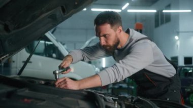 Kafkasyalı adam yorgun araba tamircisi kaputun içindeki motoru tamir etmekten yoruldu garajda ingiliz anahtarı ile tamir edilen araba tamirhanesinde bozuk otomobil bakımı onarımı