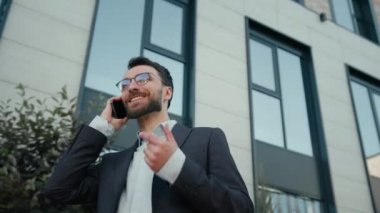 Mutlu, Kafkasyalı, yetişkin, işveren CEO 'su, gülümseyen adam, konuşan, cep telefonu konuşan, akıllı telefon görüşmeleri, gülen, açık ofis yakınlarında cep telefonu konuşmaları.