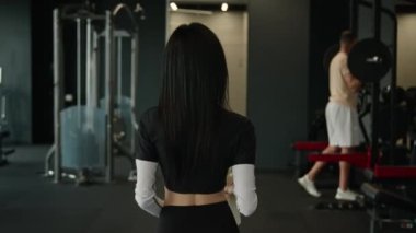 Antrenör kadın spor salonundan sonra tanınmayan bir kız olarak yürüyor spor yaparken Afrikalı Amerikalı bir adamı selamlıyor halter egzersizi yaparken mutlu iki sporcu ve sporcu beşlik çakıyor