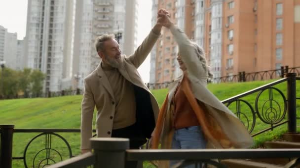无忧无虑的成熟白种人夫妇祖父母家庭共舞浪漫周年纪念日在城市公园快乐的六十岁老年女人男人出门爱快乐的男伴恋爱 — 图库视频影像