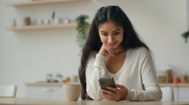 Milenyum akıllı telefon kullanıcısı Arap kadın ev sahibi bir kadına cep telefonu uygulaması kullanarak mesaj yazarak cep telefonu yemek pişirme sitesinden yemek siparişi veriyor.