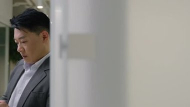 Asyalı, yorgun, yorgun, yetişkin, 40 'lı yaşlarda iş adamı cep telefonu aletlerini karıştırıyor Koreli, Çinli, orta yaşlı, Japon iş adamı işveren ofisteki akıllı telefon sorunu kaybından endişeleniyor.