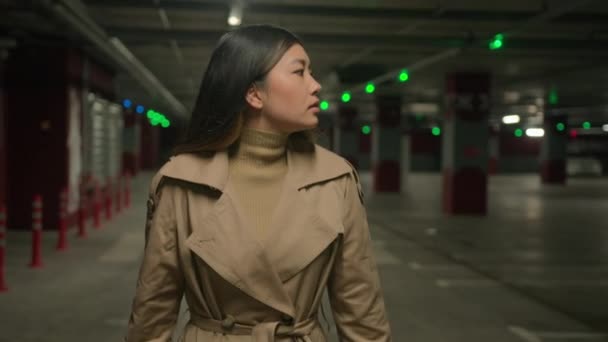 アジアの韓国人女性 日本の韓国人中国人女性自信ミレニアム実業家若いビジネスガール駐車場で自動車に歩く女性の散歩は地下で検索タクシーに行く — ストック動画