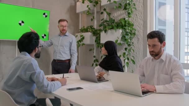 オフィスの同僚パートナー ビジネスマン ビジネスマン ビジネスマン 会議室でクロマキープレゼンテーションを検討 男性リーダーチーフ 緑の画面表示ビジネスデータ分析を示す多様なチームに話す — ストック動画