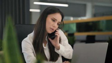 Kafası karışan ciddi iş kadını kız ofis çalışanı şirket yöneticisi iş kadını cep telefonundan konuşan kötü haber daktilo eden bilgisayar sorunu olan müşteriye danış.