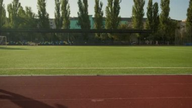 Afro-Amerikalı koşucu koşucu şehir stadyumunda aktif kardiyo koşu egzersizi yapıyor erkek sporcu maraton koşusuna hazırlanıyor sağlıklı güçlü sporcu tam görüş açısının dışında koşuyor.