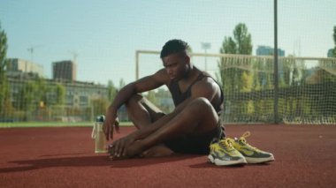Afrikalı Amerikalı futbolcu sahada acı çekiyor. Kas ağrısı, kramp, ayak krampı spor salonunda bacağını sakatlayan sporcu. Spor travması dışında bacağını sakatlayan.
