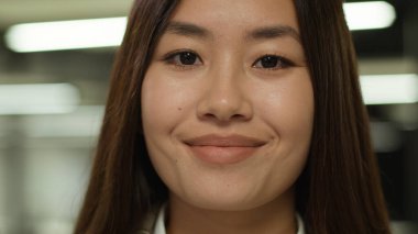 20 'li yaşlarda, gülümseyen Asyalı, genç, model, eş, iş kadını, Koreli, öğrenci, Çinli müşteri, Malezyalı, kapalı mekândaki iş kadınına bakan bir fotoğraf.