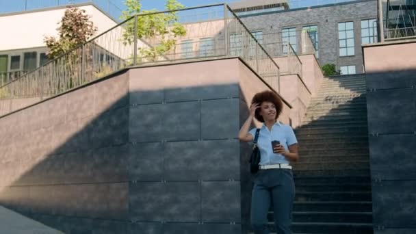 自信快乐的女商人走在城中现代商业区大写字楼旁 非洲裔美国时尚女性女士喝咖啡去散步 — 图库视频影像